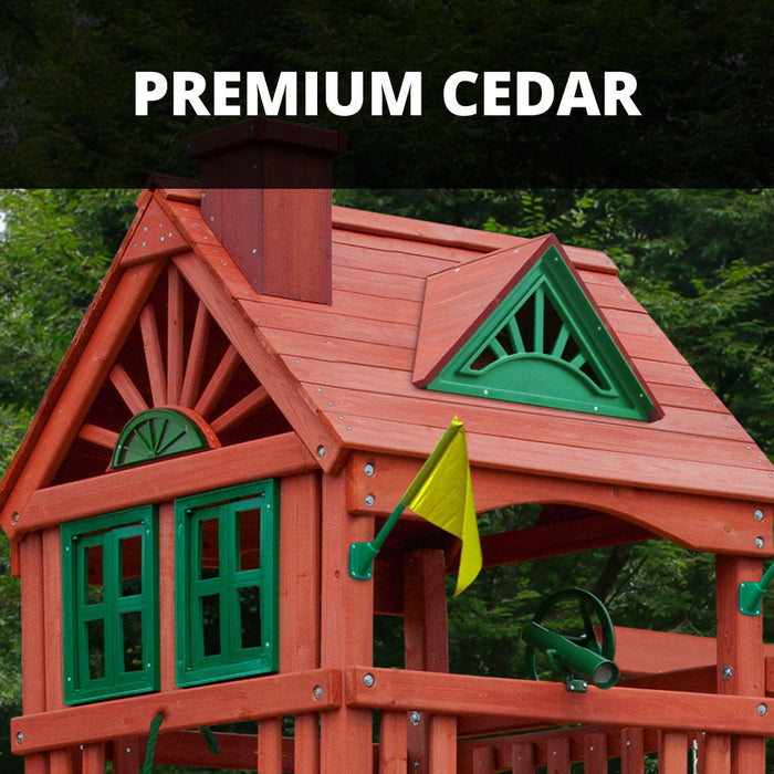 Detail shot of premium cedar treehouse roof on the Nantucket II with decorative sunburst trim, green windows, chimney, and yellow flag