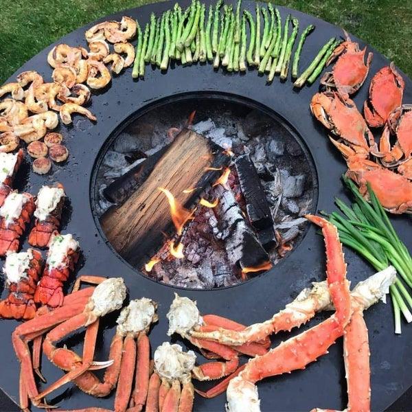  A selection of seafood and vegetables cooking on Arteflame Black Series 40" Grill, showcasing culinary versatility.