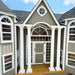Front entry of Grand Portico Mansion playhouse by Little Cottage Co. with white columns, arched windows, and detailed classic architectural design
