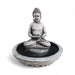Gray-tone Exaco Buddha Fountain water feature with serene statue seated cross-legged in a bowl, isolated on a white background.