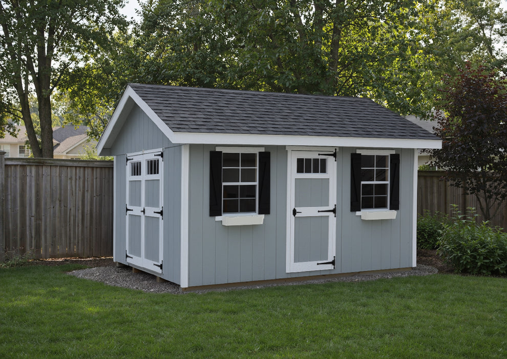 Ez-Fit Kits Riverside Outdoor Garden Shed in gray with white-trimmed double and single doors, black shutters, window flower boxes, and gravel base