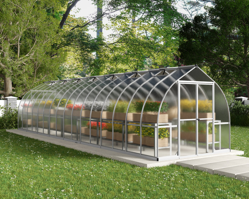 Exterior view of the Canopia Bella 8' x 32' Greenhouse showcasing vibrant plants and greenery