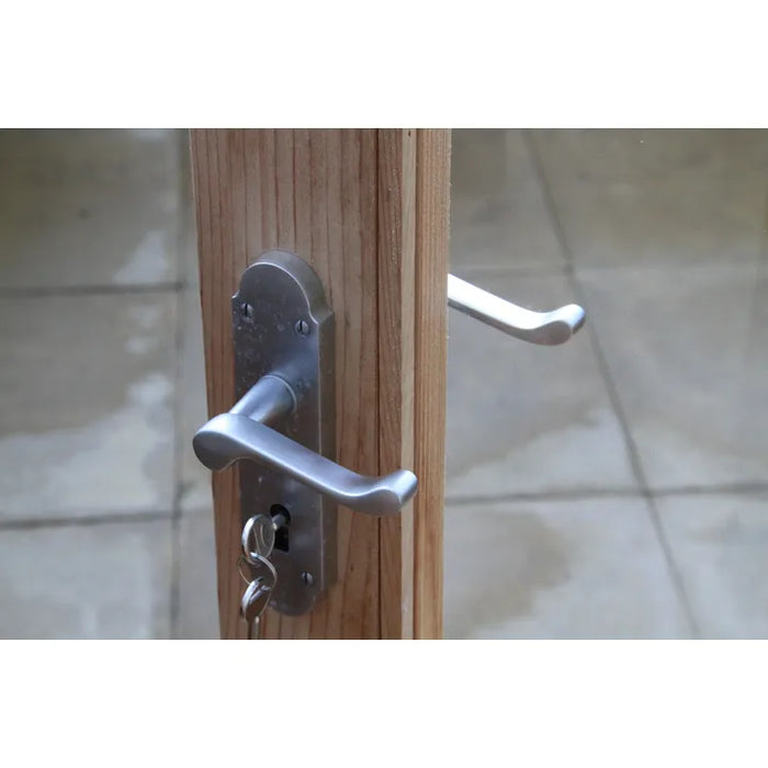 A silver door handle and lock mechanism on the Alton Lancing Greenhouse cedar door.