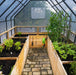 The inside of a Garden in a box with Greenhouse with plants growing in it.