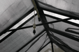 End nozzle of Riverstone Internal Watering System installed inside greenhouse roof frame for plant misting.