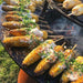 Deliciously grilled corn on the cob served on Arteflame Black Label Euro 40" Grill, showcasing its versatile cooking surface.