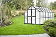 Growers Supply 12 ft greenhouse kit with black frame and translucent panels installed in landscaped backyard garden