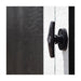 Handy Home 10x8 Acadia A close-up of a black t-shaped door handle on a white storage shed door, featuring a keyhole for added security.