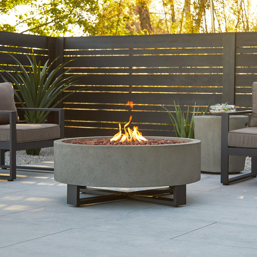 Idledale propane fire pit by Real Flame, enhancing the ambiance of outdoor living spaces 840LP-GLG-Lifestyle fire pit with two chairs outdoor