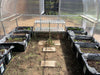 Interior view of Exaco Hoklartherm Riga Greenhouse 3 with planting trays, raised grow boxes, and aluminum bench for organized seedling growth.