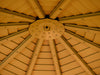 Interior view of the gazebo's roof showing a circular hook fixture for hanging accessories, surrounded by metal  roofing that allows light to permeate the space.