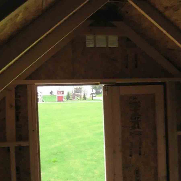 View from inside the roof structure with an open door, revealing the inviting interior of the Pennfield Cottage Playhouse by Little Cottage Company