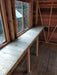 Interior view of the Alton Cedar Fusion Greenhouse showing a long wooden bench and structural wooden frame.