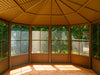 Inside view of the Gazebo with a metal roof, showing a dining set ready for guests, with clear views of the surrounding landscape through the screened panels.