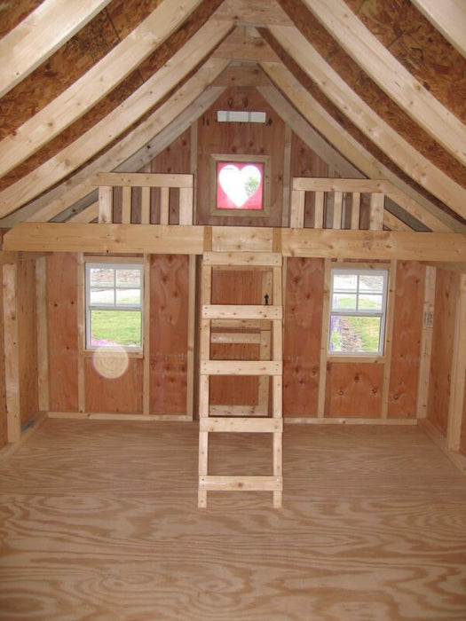 Interior view of the Little Cottage Company Gingerbread Cottage Playhouse featuring a loft with ladder and heart-shaped window.