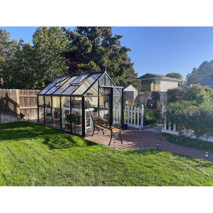 Charming Exaco Janssens Junior Victorian Greenhouse in a serene backyard with a white picket fence and manicured lawn.