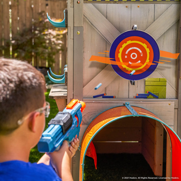 Kid aiming a play gun inside the wooden playhouse