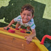 A kid climbing on the cave lodge set