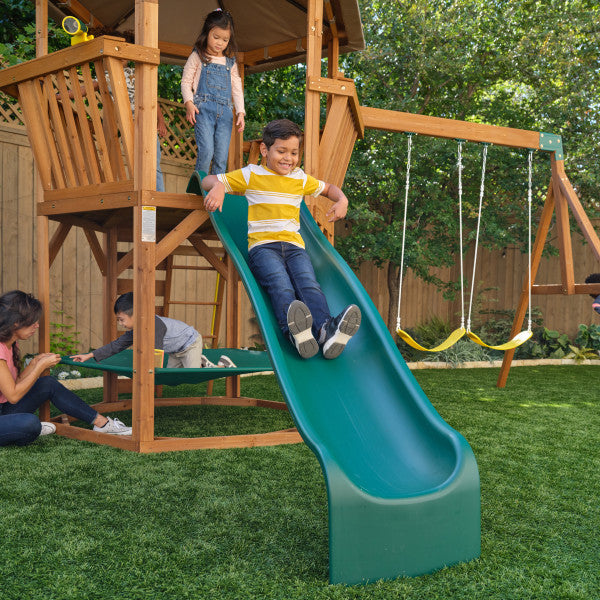 A kid sliding on the outdoor playset