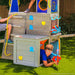 Kid playing on the outdoor wooden playhouse