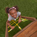 A kid climbing on the wooden swing set