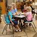 Children seated on Lifetime 13 Pack Children's Stack Chair at small dining table with plates in home kitchen