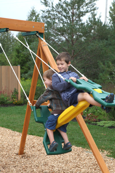 Kids swinging on the outdoor wooden playset