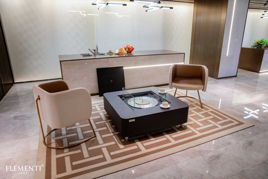  Slate black Elementi Perth Ethanol Fire Table placed in a modern kitchen-lounge setting with chairs