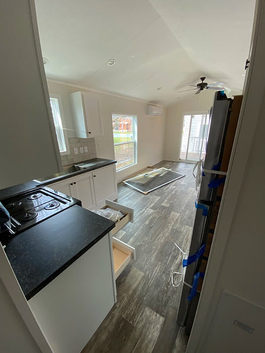 View of the kitchen under construction in the Champion Home No Loft, showcasing cabinetry and appliances.