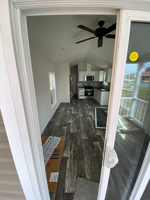 Perspective from the porch into the kitchen of the Champion Home No Loft by Oasis Tiny Estates, highlighting the modern interior.