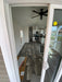 Perspective from the porch into the kitchen of the Champion Home No Loft by Oasis Tiny Estates, highlighting the modern interior.