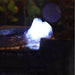 Close up of Yang water fountain LED light at the top, highlighting glowing water feature and textured stone surface at night.