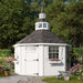 The 12x12 Garden Shed Greenhouse placed in a landscaped garden scene by Little Cottage Co.