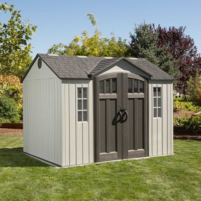 Lifetime 10x8 ft. storage shed in a backyard, front angle view with closed double doors and decorative shutters.