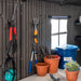 Interior of a Lifetime 20x8 storage shed, showing garden tools hanging on the wall and potted plants arranged on a shelf.