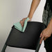 Close up of black Lifetime 4-Pack Classic Folding Chair being wiped clean to show stain resistant surface