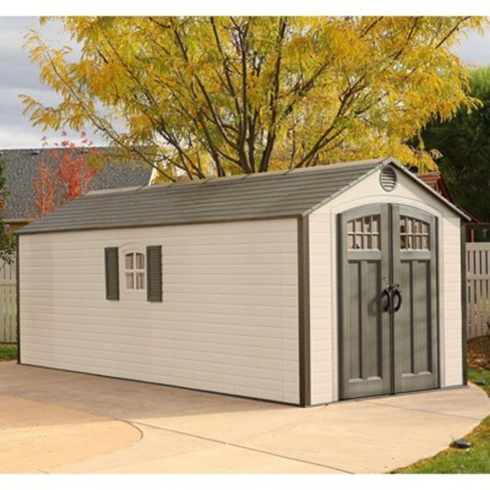 Lifetime 8x20 ft. storage shed installed on a driveway with autumn trees, front angle view with closed doors.
