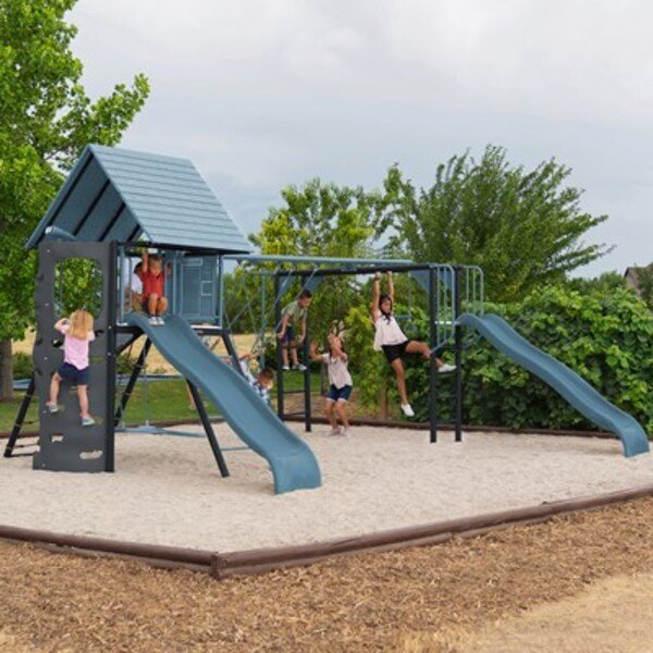 Lifetime Big Stuff Deluxe playset installed in a backyard with kids playing on the slides, monkey bars, and swings.