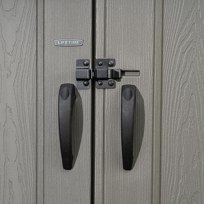 Close-up of the Lifetime-branded door handles and slider latch on the storage shed.