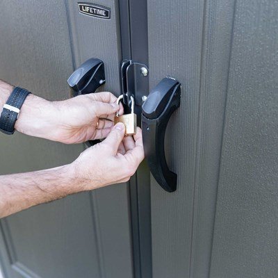 Close-up of a padlock securing the Lifetime-branded storage shed's door handles.