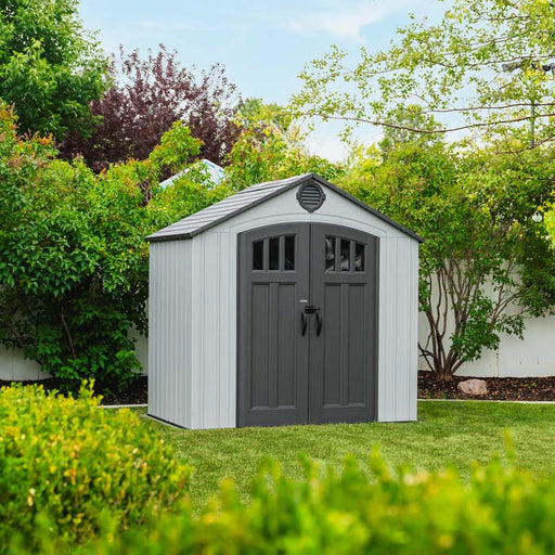 Lifetime Classic 8x5 Garden Shed closed, shown in a backyard setting with greenery.