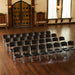 Rows of Lifetime Classic Commercial Folding Chairs arranged for an indoor event with wood flooring and rustic double doors in background