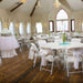 Event hall setup with Lifetime 4 Pack White Classic Folding Chairs arranged around round tables