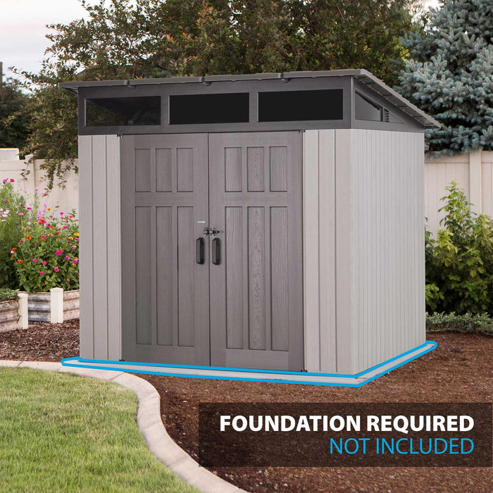 Lifetime Farmhouse Storage Shed 60542 installed in a backyard garden setting with wood-grain double doors, skylight windows, and foundation required callout