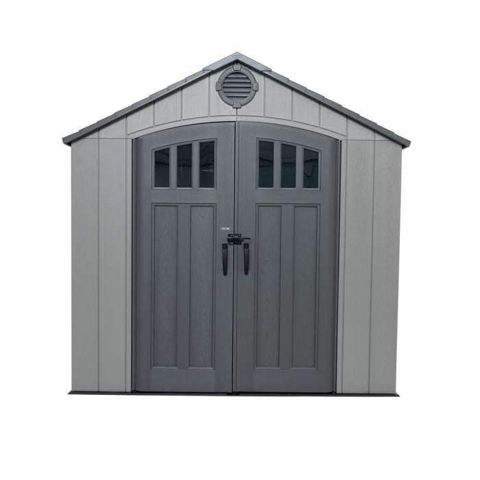 A light gray Lifetime 20' x 8' outdoor storage shed with darker gray double doors and a wood grain texture. The doors have arched windows and a padlock on the handle. There is a circular vent above the doors. 