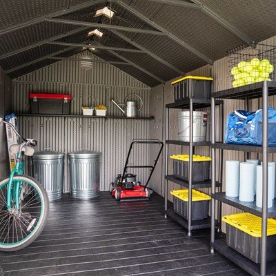Interior of the Lifetime 8x15 ft. storage shed with a bike, lawn mower, trash cans, and shelving unit.