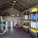 Interior of the Lifetime 8x15 ft. storage shed with a bike, lawn mower, trash cans, and shelving unit.