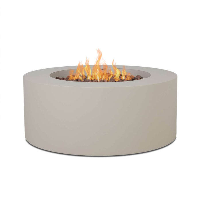 Real Flame Aegean round propane fire pit table in light sand finish with lava rocks and flames, angled cylindrical product view on white