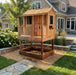 Little Cedar Playhouse 6x6 without slide attachment, set on a mulch base near a stone patio with hydrangeas