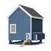 Blue Little Cottage Co. 6x8 Chicken Coop with white trim, featuring a nesting box, small window, and wooden ramp entry on raised frame.